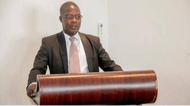 Dr. Zizwa Msukuma at a formal podium — a reflection of his authority as a published scholar and institutional leader